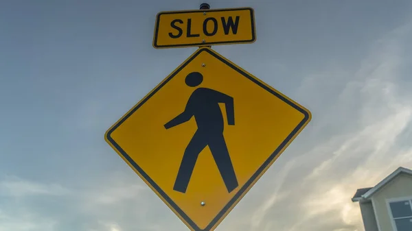 Panorama frame Yellow Slow sign and pedestrian crossing sign against cloudy sky at sunset — Stock Photo, Image