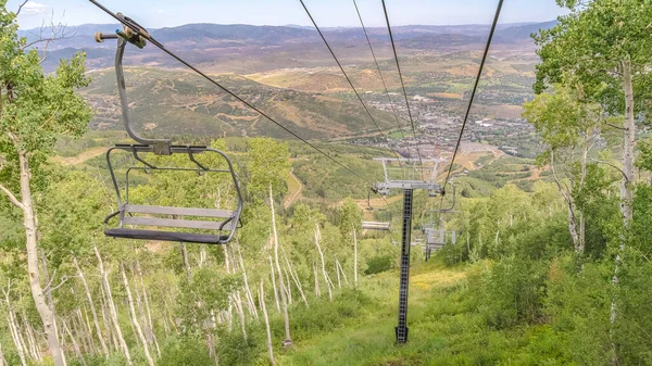 Panorama Wandelpaden en stoeltjesliften in een skigebied bedekt met groen in de zomer — Stockfoto