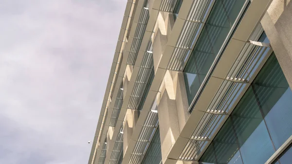 Panorama Moderno edificio de oficinas exterior visto contra el cielo nublado en un día soleado — Foto de Stock