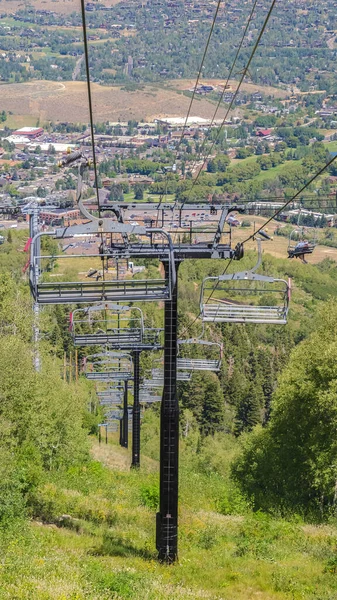 Vertical frame Chairlifts looking trails and building on the Summer day in Park City — стокове фото