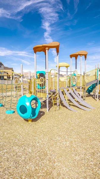 Вертикальна рамка Дитячий майданчик з різнокольоровими синіми слайдами вдень — стокове фото