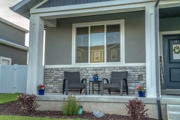 Domácí fasáda s verandou a předními dveřmi zdobené květináči a věnec — Stock fotografie