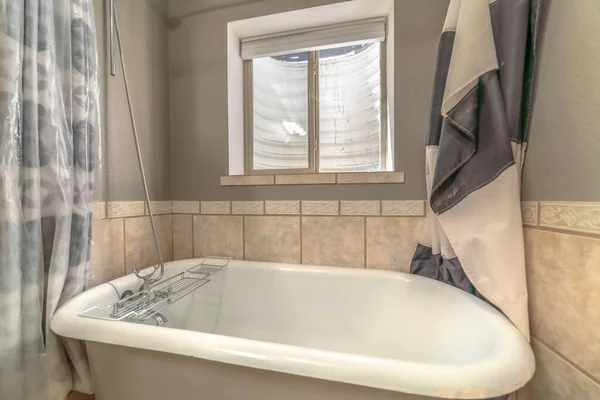 Blisko wanny z boku łazienka z zasłonami prysznicowymi i oknem — Zdjęcie stockowe
