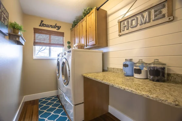 Laundry room of a home with washing machine against the wall and small window