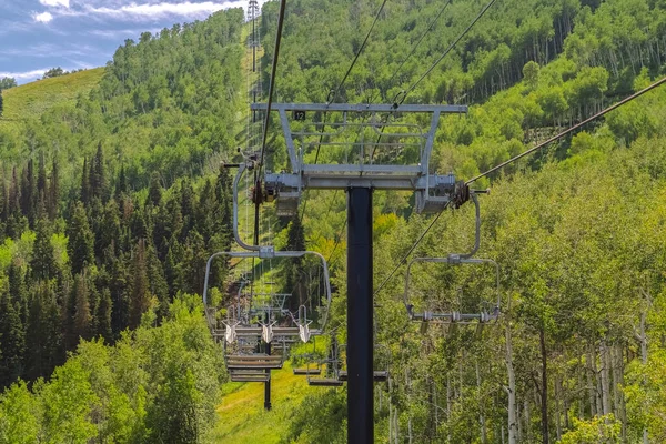 Stolar lyfter över rikligt med gröna träd och vandringsleder under lågsäsong månader — Stockfoto