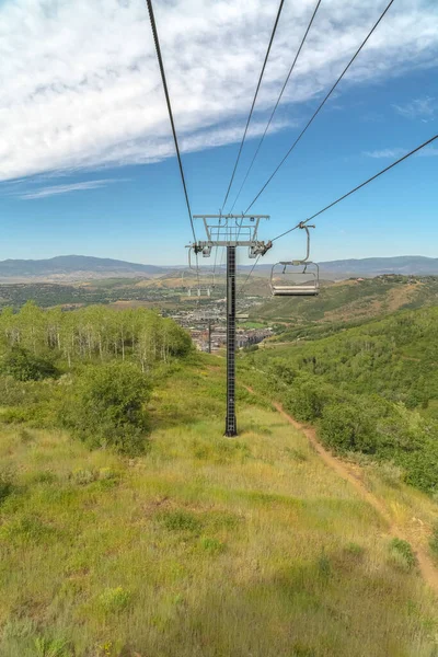 Focus op stoeltjesliften tegen berglucht en wolken in Park City in het laagseizoen — Stockfoto