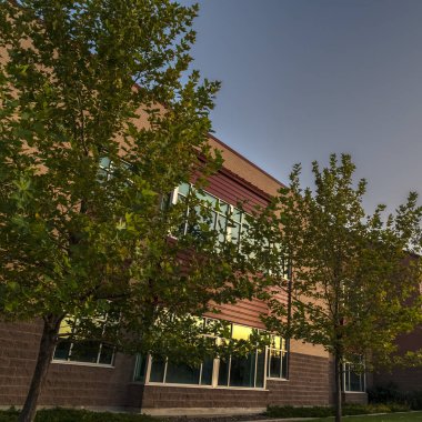 Gün batımına yakın ağaçlarla çevrili şehir merkezi cephesi