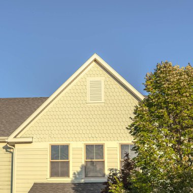 Akşam ışığında büyük sarı bir evin kare cephesi