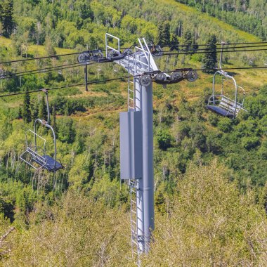Kare çerçeve, sezon dışında yürüyüş patikaları olan telesiyej ve dağ manzaralı.