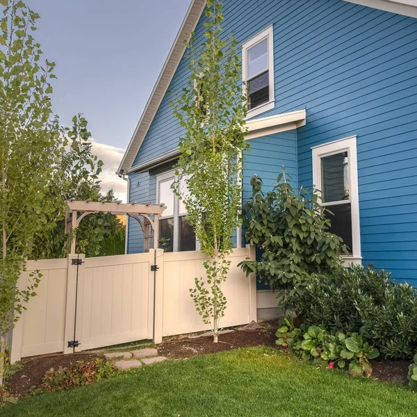 Голубой деревянный дом с огороженным садом — стоковое фото