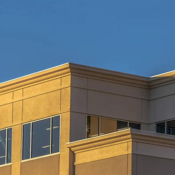 Marco cuadrado Fachada de un edificio comercial con grandes ventanas de vidrio contra el cielo azul claro — Foto de Stock