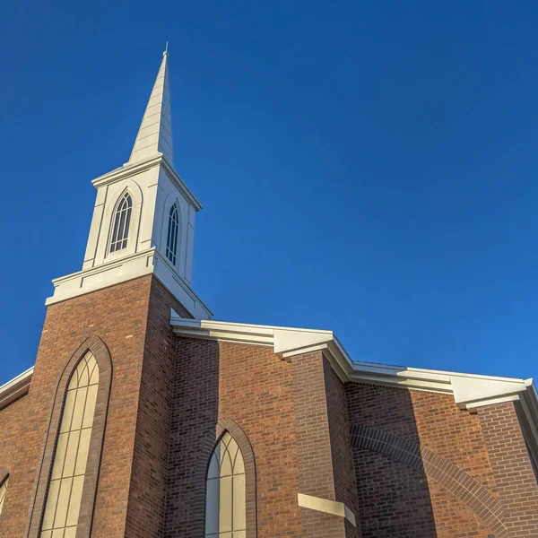 Square Church with classic red brick exterior wall and white steeple against blue sky — Stock Photo, Image