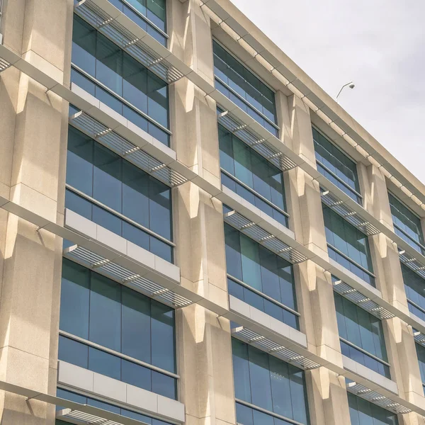 Négyzet alakú keret Modern épület homlokzat közel üvegablakokkal és napfényes betonfallal — Stock Fotó