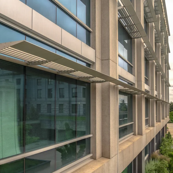 Square Office building exterior with close up on the glass windows and concrete wall — 스톡 사진