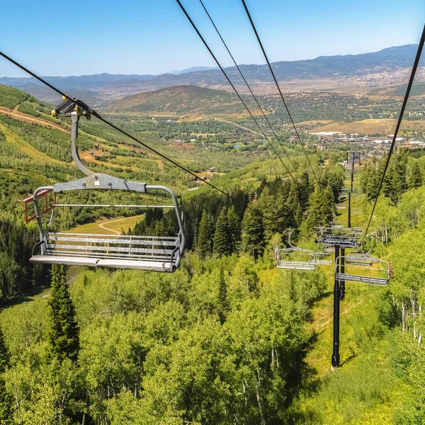 公园城滑雪胜地的正方形框架，带椅子电梯，覆盖高山和绿地 — 图库照片
