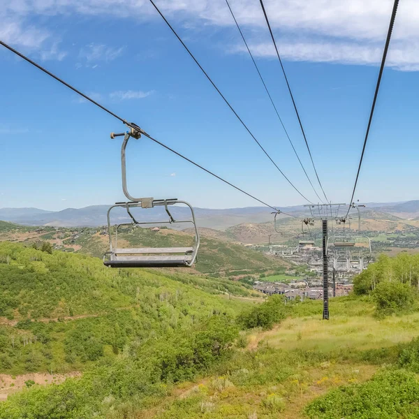 Square frame Hiking trails and vibrant foliage under chairlifts and blue sky at off season