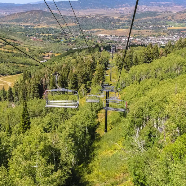 Vierkante stoeltjesliften en uitzicht vanuit de lucht op bergwandelpaden en gebouwen in de zomer — Stockfoto