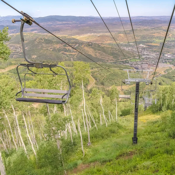 夏天，在一个绿意盎然的滑雪胜地，广场上的小径和椅子电梯 — 图库照片
