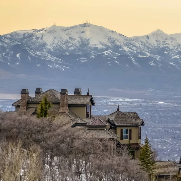 Marco cuadrado Casas de colina con nieve lejana toweing montaña sobre lago y valle —  Fotos de Stock