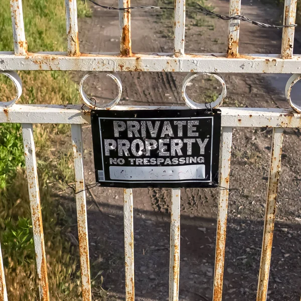 Square Locked rusty old gate with private property sign and view of lake and mountain — Stock Photo, Image