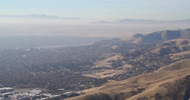 Pan la stânga unei vederi telephoto din centrul orașului Salt Lake City cu o pasăre care zboară prin cadrul central — Videoclip de stoc