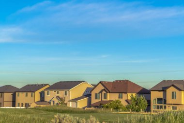 Mavi gökyüzüne karşı gable, vadi ve kalça çatılı evler.