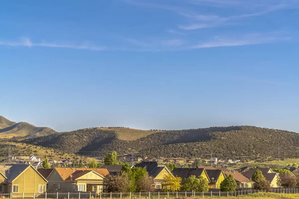 Güneşli bir günde evlerin manzarası dağ ve mavi gökyüzü arka planında — Stok fotoğraf