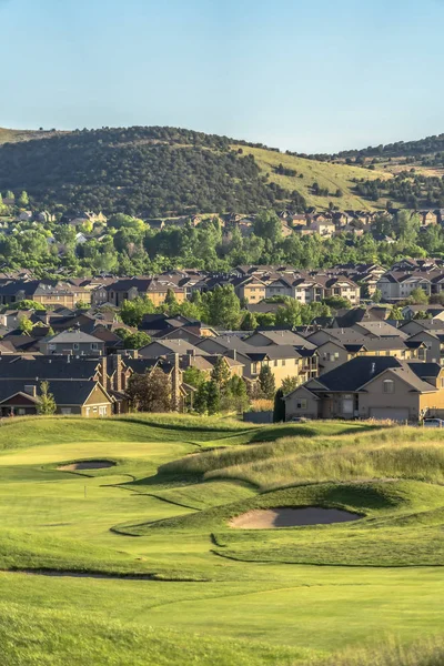 Maisons en banlieue avec vue sur un terrain de golf et montagne sous le ciel bleu — Photo