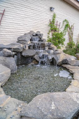 Güneşli bir günde çağlayan şelaleli açık hava taş süslemesi