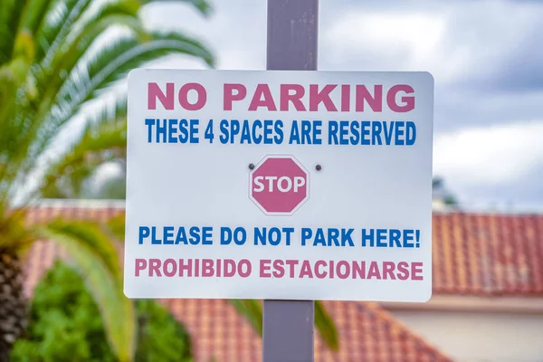 No parking in reserved spaces warning sign