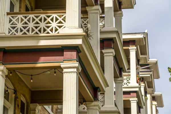 Cierre de columnas cuadradas y barandilla de celosía que enmarca el balcón de las casas adosadas — Foto de Stock