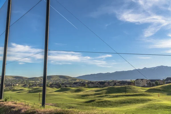 Φράχτης με γραφική θέα των σπιτιών γήπεδο γκολφ και το βουνό σε μια ηλιόλουστη μέρα — Φωτογραφία Αρχείου