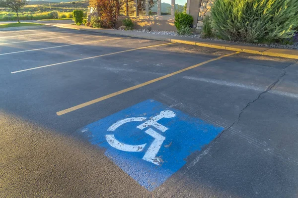 Handicapped parking space at a parking lot outside a building on a sunny day — 스톡 사진