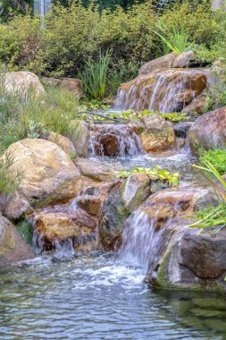 Küçük şelale yapraklı kayaların üzerinde çağlıyor.