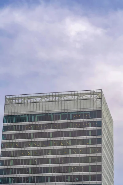 Moderno edificio comercial exterior con altas ventanas de cristal contra el cielo nublado — Foto de Stock