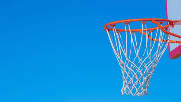 Panorama Zavřít na basketbalové síti proti modré obloze při západu slunce — Stock fotografie