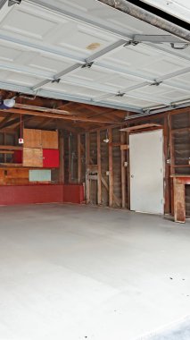 Dikey garaj kapıları açık ve ahşap destekli bir garaj var.