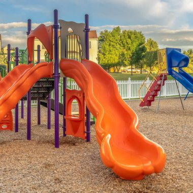 Kare parlak turuncu ve mavi slaytlar çocuklar için renkli bir oyun parkında