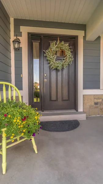 Verticale veranda en gevel van thuis versierd met kleurrijke bloemen en krans op de deur — Stockfoto