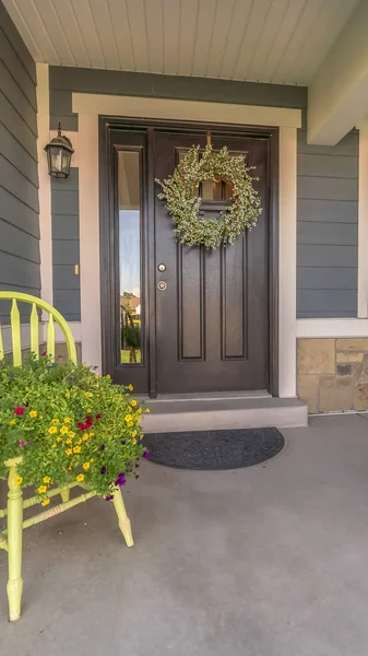 Vertical Porch and facade of home decorated with colorful flowers and wreath on the door — Stock Photo, Image