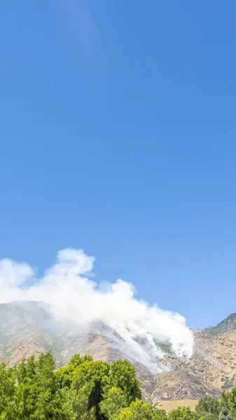 Cadre vertical Vue panoramique sur la nature par une journée ensoleillée avec la fumée du feu dans les montagnes — Photo