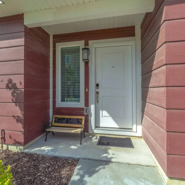 Square frame Close up of townhouse facade with a bench by the white front door and window — Stock Photo, Image