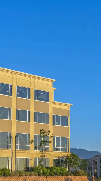 Vertical Empty parking lot with buildings mountain and blue sky view on a sunny day