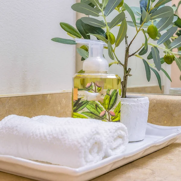 在一个干净的浴室里放有面部毛巾、肥皂和盆栽的正方形框架托盘 — 图库照片