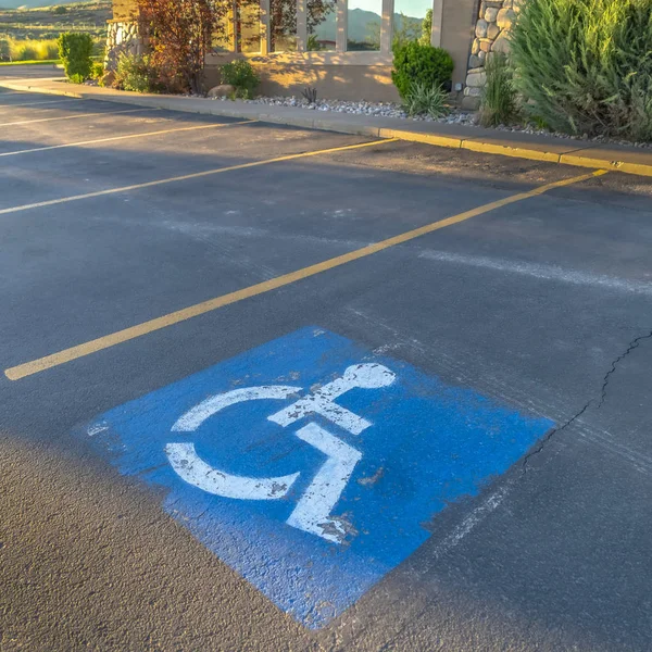 Plac Miejsce parkingowe dla niepełnosprawnych na parkingu przed budynkiem w słoneczny dzień — Zdjęcie stockowe
