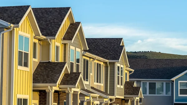 Casas adosadas con pared exterior de madera y ladrillo contra la montaña y el cielo azul — Foto de Stock