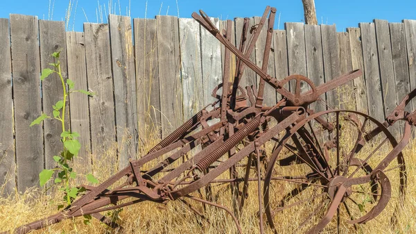 Pano Oude vintage landbouwtrekker tegen grassen en houten hek op een zonnige dag — Stockfoto