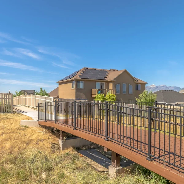 Plaza Vista lateral del puente que conduce al sendero en medio de las casas en un día soleado — Foto de Stock