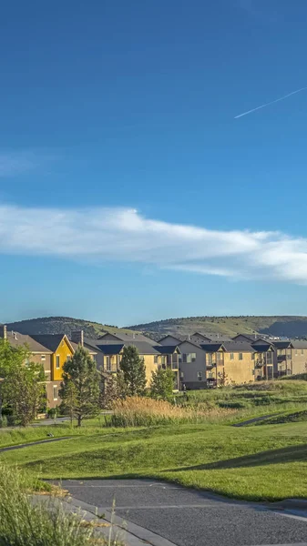Marco vertical Casas alrededor de un campo de golf con fondo escénico de montaña y cielo azul — Foto de Stock