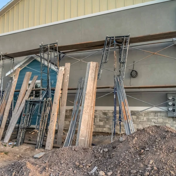 Square frame Residential construction with scaffolding and wooden beams against wall of home — Stock Photo, Image